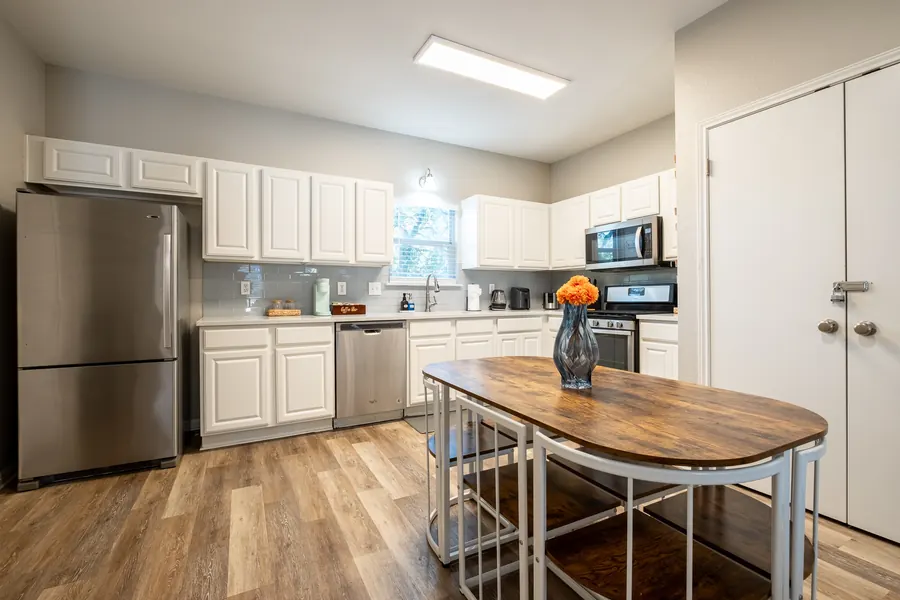 1413 Luna Street kitchen after grading — white cabinetry reading neutral, warm oak floor, even exposure across the room.