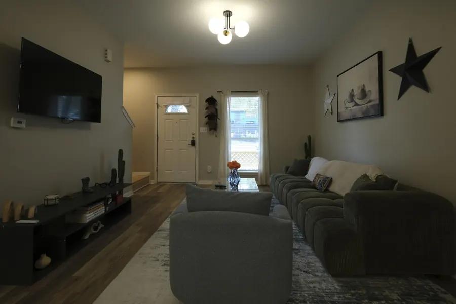 The same living room straight out of camera — dull, warm-cast and underexposed with a flat window.