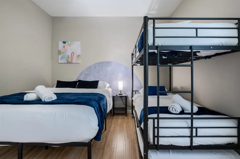 Bunk room from the doorway, twin bed and bunks with rolled towels.