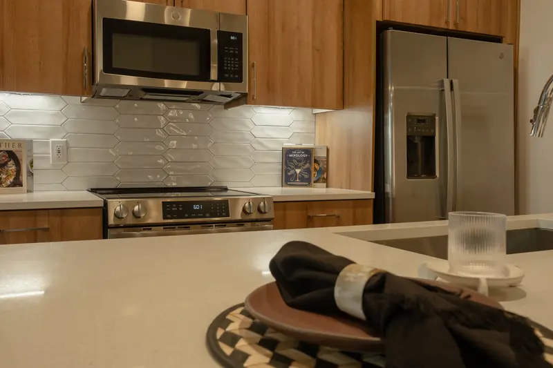 Styled counter detail — plate, linen napkin and glassware on quartz.
